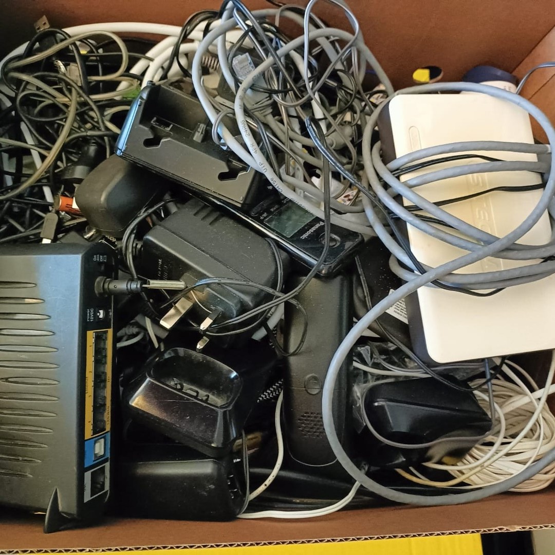 E-waste, wires, chargers in a cardboard box
